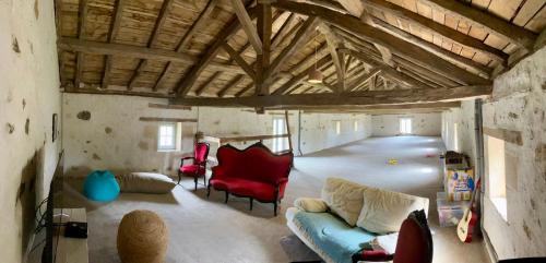 un salon avec un canapé et des chaises rouges dans l'établissement Gîte de Font Valet, à Millac