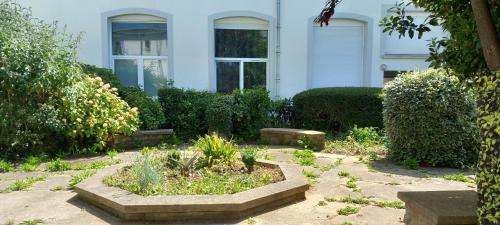 a garden in front of a white house at Studio 30 m2 refait à neuf idéalement situé centre ville et plage in Wimereux