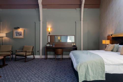 ein Hotelzimmer mit einem Bett und einem Schreibtisch in der Unterkunft The Greyhound Wetherspoon in Bridport