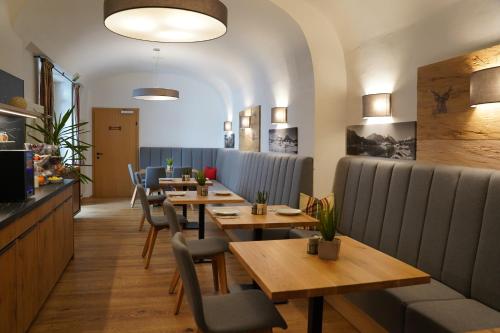 a restaurant with wooden tables and blue chairs at Hotel Der Greif in Leoben