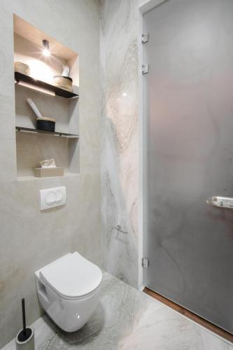 a bathroom with a white toilet and a shower at Villa Invicta with 17m pool and bay view in Kotor