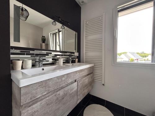 une salle de bain avec un grand lavabo et une fenêtre dans l'établissement La Villa des petits bonheurs, à Saint-Quay-Portrieux