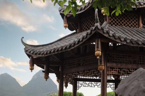 a roof of a building with mountains in the background at 阳朔归云檀邸民宿 in Yangshuo