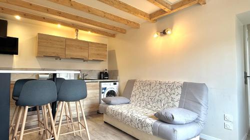 - un salon avec un canapé et deux tabourets dans l'établissement T2 proche autoroute et gare, à Belleville-en-Beaujolais