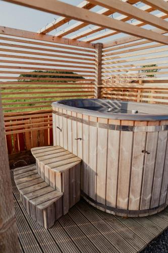 a hot tub sitting on top of a wooden deck at Bamburgh Under Canvas in Bamburgh