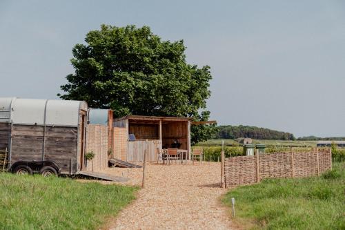 a farm with a trailer and a fence at Bamburgh Under Canvas in Bamburgh