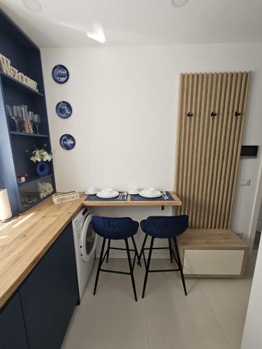 a small kitchen with a table and two stools at Silvery Studio 22 in Rădăuţi