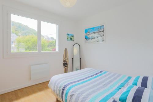 une chambre blanche avec un lit et une fenêtre dans l'établissement Le petit Rozeur - appt vue mer, à Plérin
