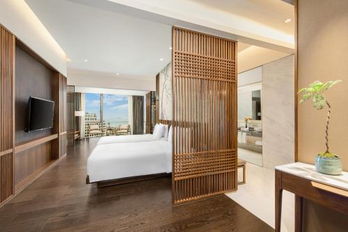a hotel room with a bed and a television at Serensia Woods Wellness Resort in Zhuhai