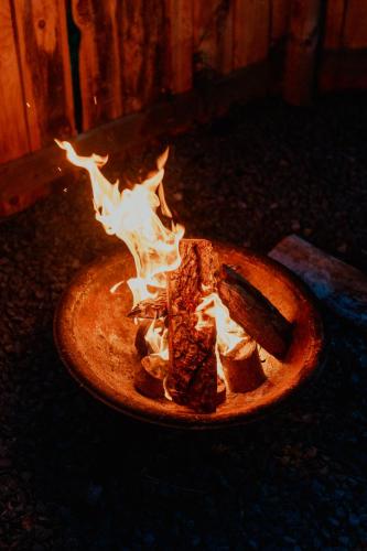a fire pit with a piece of food in it at Bamburgh Under Canvas in Bamburgh