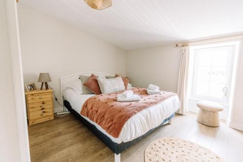 une chambre avec un lit et une fenêtre dans l'établissement La Do Ré - Élégante et chaleureuse maison à La Noue, à Sainte-Marie de Ré
