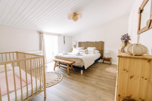 ein Schlafzimmer mit einem Bett und einem Kinderbett in der Unterkunft La Do Ré - Élégante et chaleureuse maison à La Noue in Sainte-Marie-de-Ré