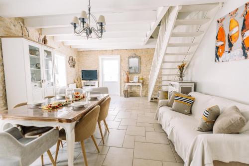 ein Wohnzimmer mit Tisch und Couch in der Unterkunft La Do Ré - Élégante et chaleureuse maison à La Noue in Sainte-Marie-de-Ré