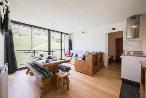 un salon avec une table et un canapé dans l'établissement Le Chrystal des Neiges - Le Corbier - Vue pistes, à Villarembert