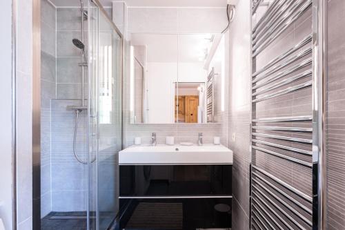 une salle de bain avec un lavabo et une douche dans l'établissement Le Chrystal des Neiges - Le Corbier - Vue pistes, à Villarembert