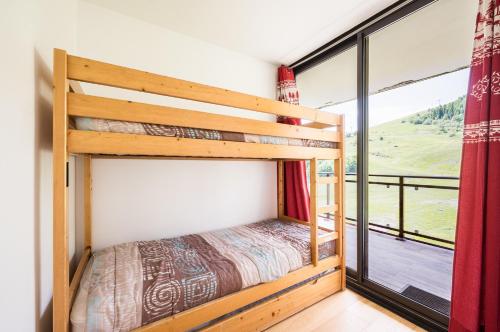 une chambre avec un lit superposé et une grande fenêtre dans l'établissement Le Chrystal des Neiges - Le Corbier - Vue pistes, à Villarembert