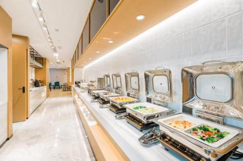a buffet line with plates of food on display at Atour Hotel Hangzhou West Lake Cultural Plaza Shangtang Road in Hangzhou