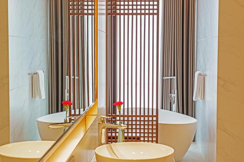 a bathroom with two sinks and two toilets at Serensia Woods Wellness Resort in Zhuhai