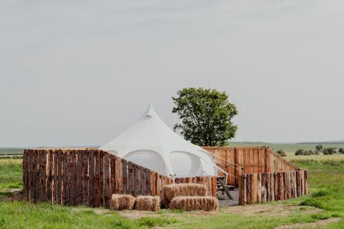 a tent in a field with stacks of hay at Bamburgh Under Canvas in Bamburgh