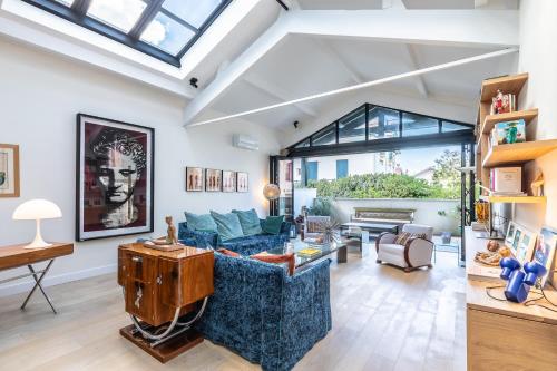 a living room with a blue couch and a table at Villa Elisa - Maison esprit loft 500m plage in Biarritz