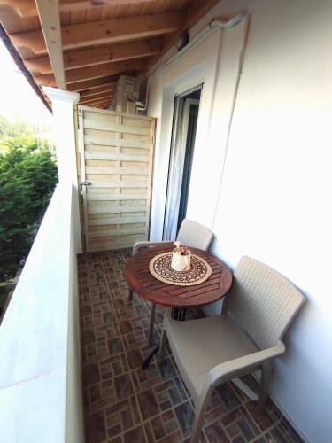 a small table and chairs on a balcony at Rita's Home in Acharavi