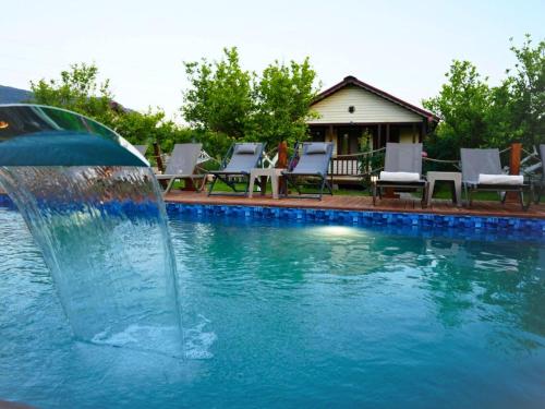 a water fountain in the middle of a swimming pool at İztuzu Bungalow & Camping in Ortaca
