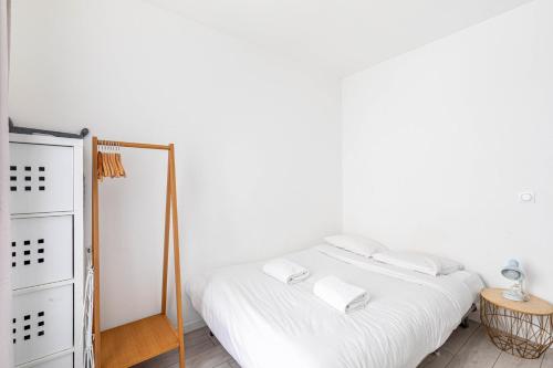 - une chambre blanche avec un miroir et un lit dans l'établissement GuestReady - Serene base two steps from Paris, à Boulogne-Billancourt