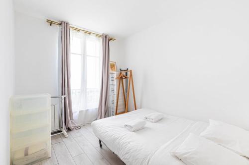 une chambre avec un lit blanc et une fenêtre dans l'établissement GuestReady - Serene base two steps from Paris, à Boulogne-Billancourt