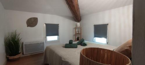 a bedroom with a bed with a teddy bear on it at AppartZen proche Cité de Carcassonne et lac de la Cavayère in Trèbes