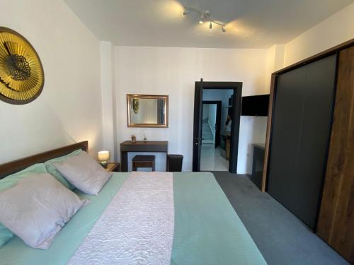 a bedroom with a bed and a desk and a mirror at Sea Breeze Retreat - Comfort Apartments in the Heart of Sliema in Sliema