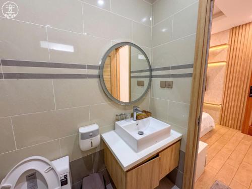 a bathroom with a sink and a mirror and a toilet at KING Hotel in Vung Tau