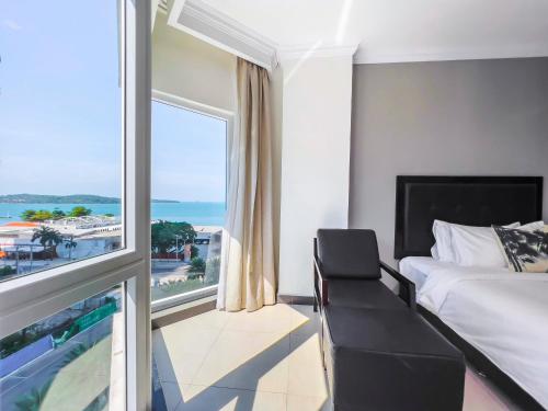 a bedroom with a bed and a large window at Queenco Hotel & Casino in Sihanoukville