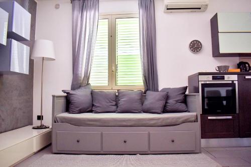 a couch in a living room with a window at Casa Vacanze "A Machina Ro Ghiaccio" in Noto