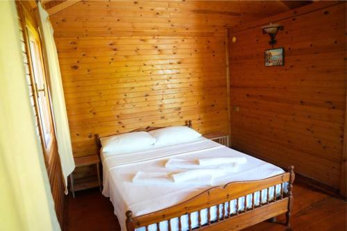 a bedroom with a bed in a wooden room at İztuzu Bungalow & Camping in Ortaca