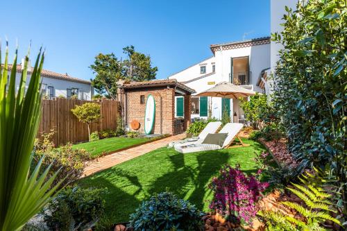 un jardin avec une terrasse et une maison dans l'établissement La Casucha - Maison de ville, jardin, hammam, à Biarritz