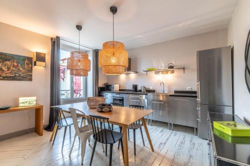 une cuisine avec une table et des chaises en bois dans l'établissement Romy - En centre-ville, à Biarritz