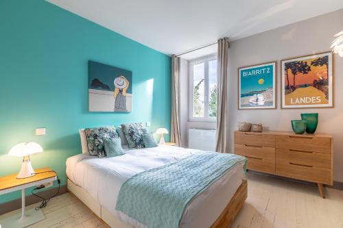 - une chambre bleue avec un lit et un bureau dans l'établissement Romy - En centre-ville, à Biarritz