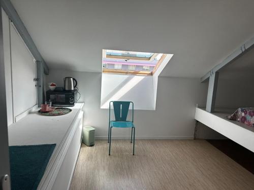 a blue chair in a room with two bunk beds at Magnifique maison coloniale in Noumea