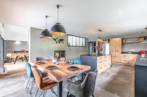 a kitchen and dining room with a wooden table and chairs at Villa Samare - Avec piscine à 5 min des plages in Anglet