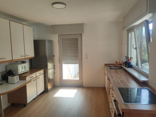 a kitchen with white cabinets and a wooden counter top at Monteurzimmer Mühlheim am Main Nähe S-Bahn in Mühlheim