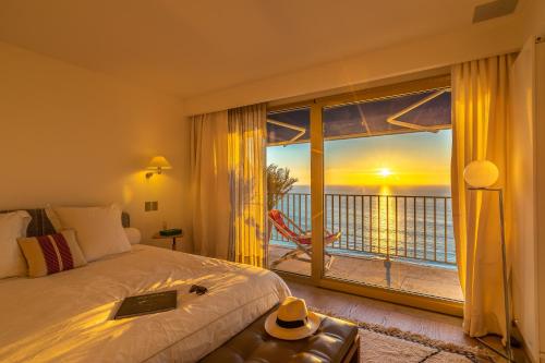a bedroom with a bed and a large window with a view at Sunset - Vue exceptionnelle sur l'océan in Biarritz