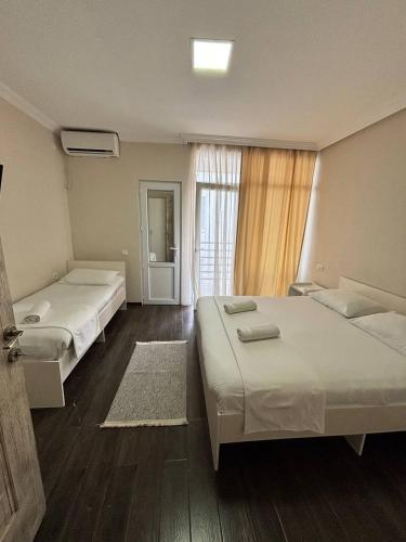 a hotel room with two beds and a window at Guest House Kobuleti 516 in K'obulet'i