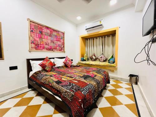 a bedroom with a bed with a colorful blanket at Thar Tribe Hostel Jaisalmer in Jaisalmer