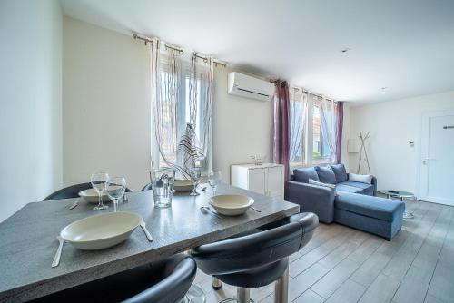 un salon avec une table avec des chaises et un canapé dans l'établissement Villa Welcom 4 - 2min à Pied de la Plage, à Canet