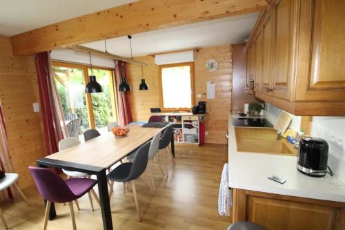 une cuisine et une salle à manger avec une table et des chaises dans l'établissement Chalet avec mezzanine 4 étoiles, Saint Mamet, jusqu'à 10 couchages, proche du lac de Gérardmer des commerces et des pistes de ski dans un quartier calme, à Gérardmer