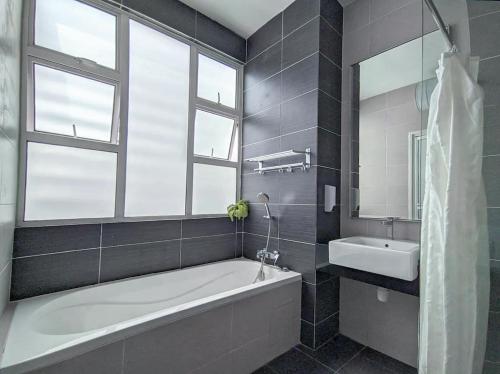 a bathroom with a bath tub and a sink at d'Fun 5BR16-24px Pool BBQ NetFlx HotPot KTV Mahjong by Our Stay in Ulu Tiram