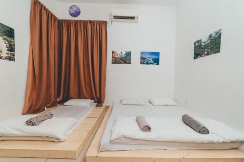 two beds in a room with a window at d'Fun 5BR16-24px Pool BBQ NetFlx HotPot KTV Mahjong by Our Stay in Ulu Tiram