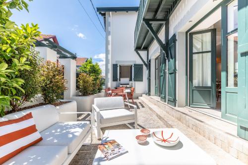 a patio with a white couch and a table at Villa Mila - A 450 m de la plage in Biarritz
