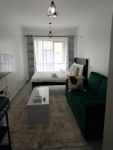 a living room with a bed and a green couch at Heavenly Castles in Ongata Rongai 