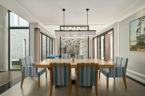 a dining room with a wooden table and blue chairs at Renaissance Danang Hoi An Resort & Spa in Hoi An